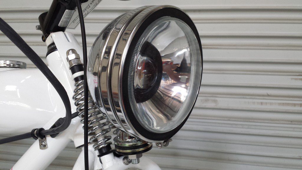 A close up of a white bicycle with a light on it.