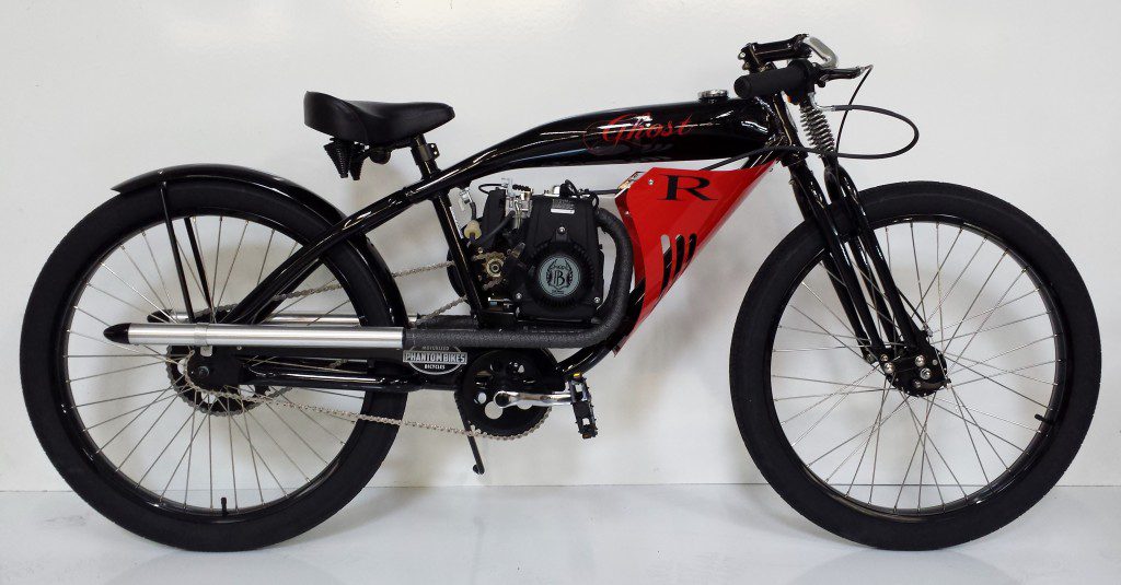 A black and red motorcycle is parked against a white wall.