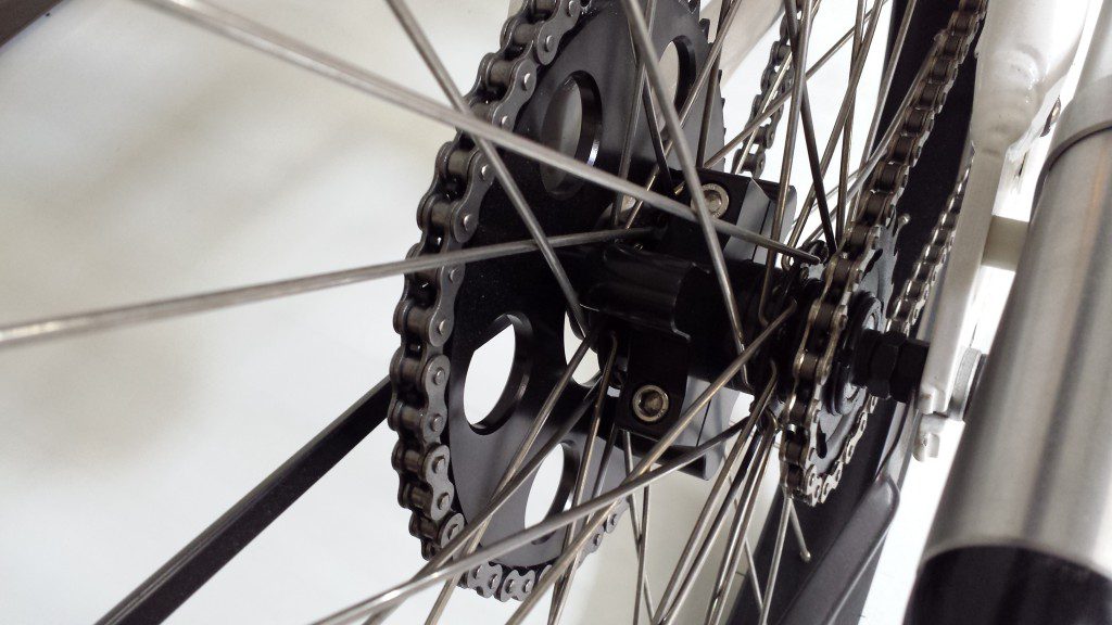 A close up of a bicycle wheel and chain.