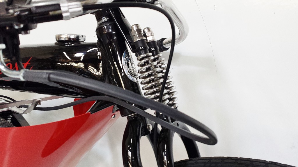 A close up of a bike with a red and black handlebar.