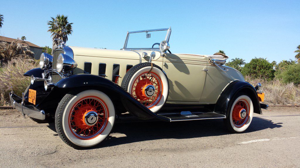 An antique car parked on the side of the road.