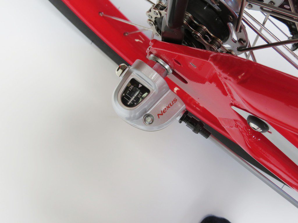 A close up of a red bicycle with a red handlebar.