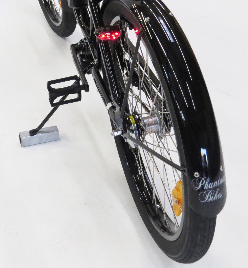 A black bicycle with a red light on the handlebars.