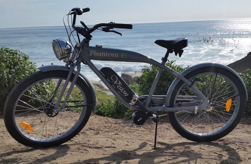 An electric bike is parked in front of the ocean.