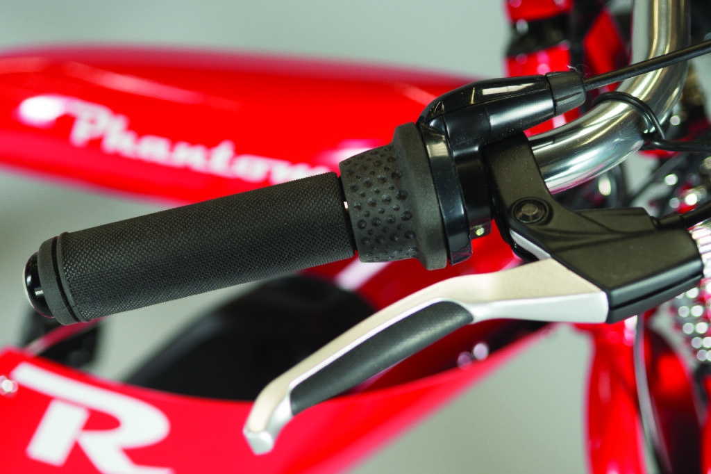 A close up of a handle on a red bicycle.