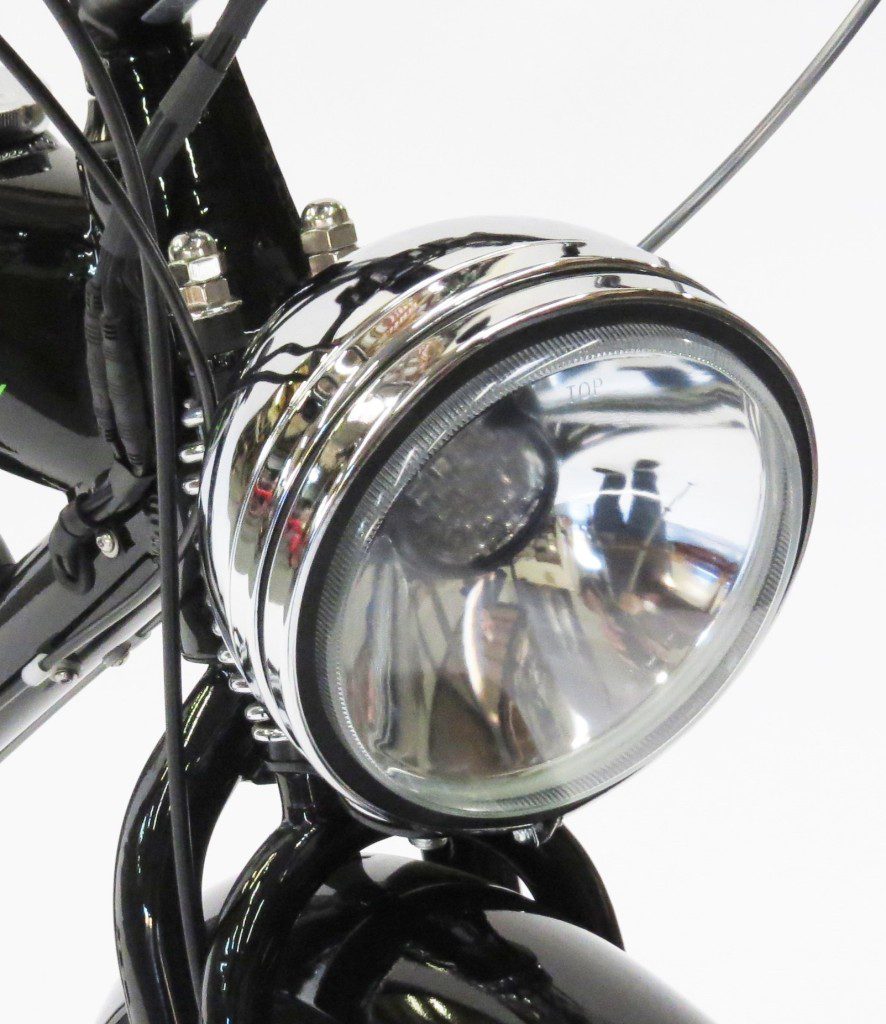 A close up of the headlight of a black motorcycle.