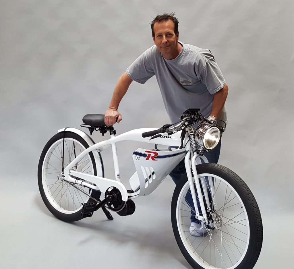 A man standing next to a white electric bike.