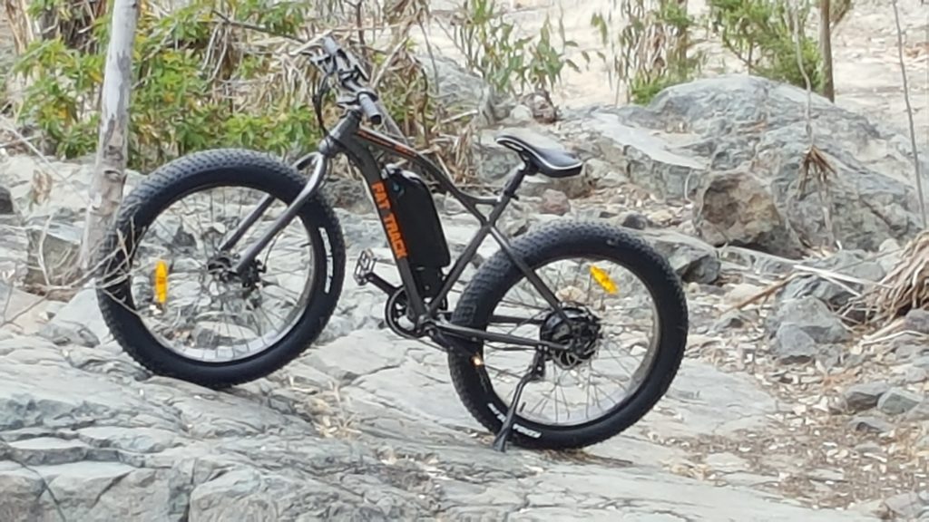 A fat bike is parked on a rocky cliff.