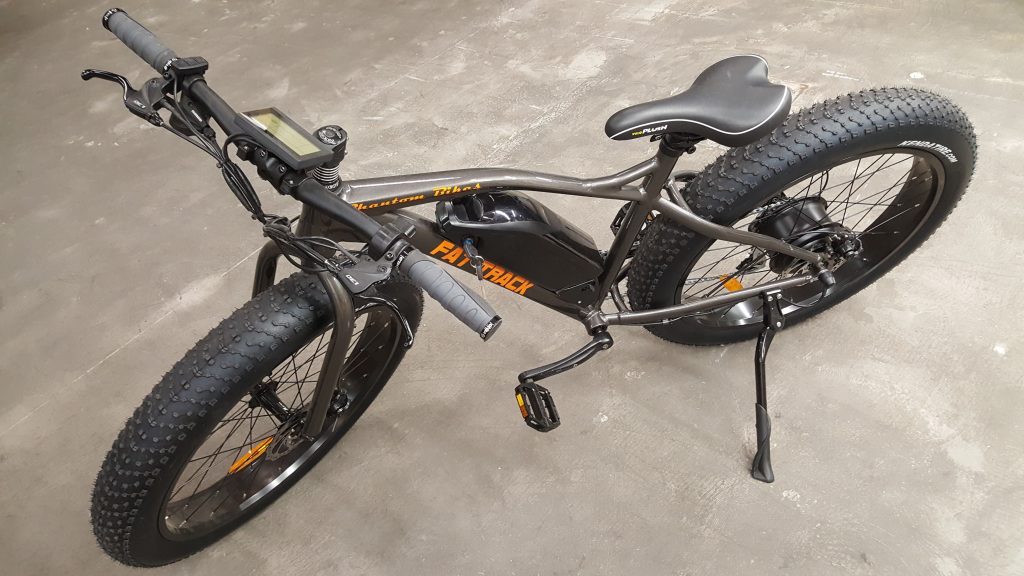 An electric fat bike is parked on a concrete floor.