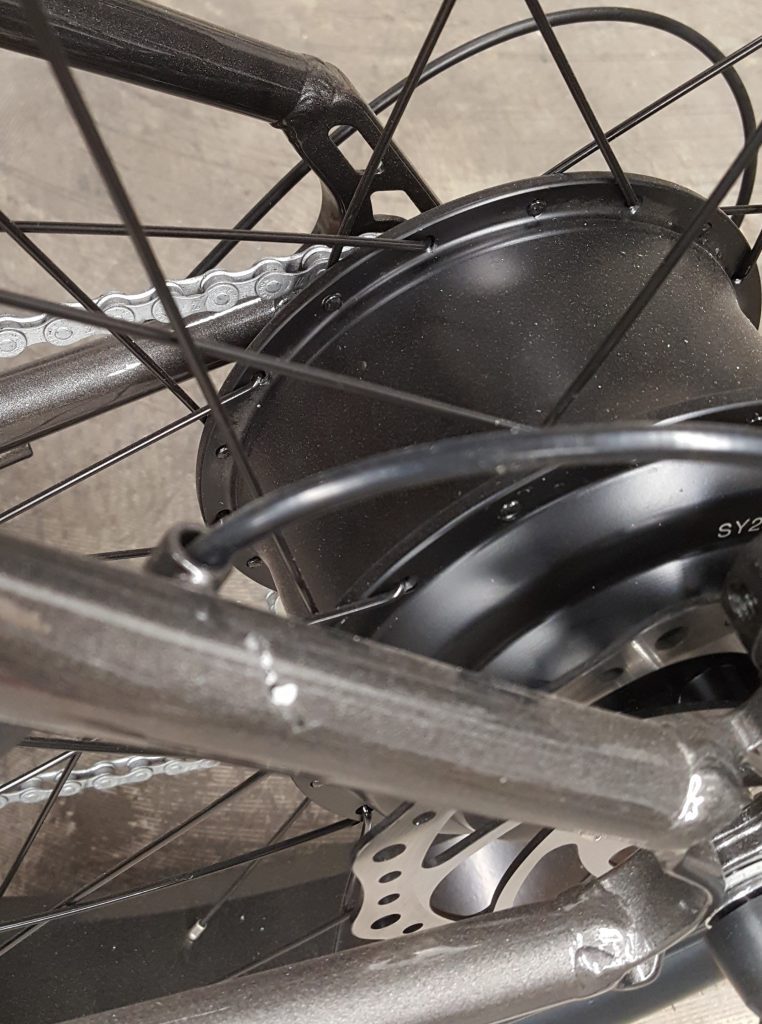 A close up of a bicycle wheel with a chain and spokes.