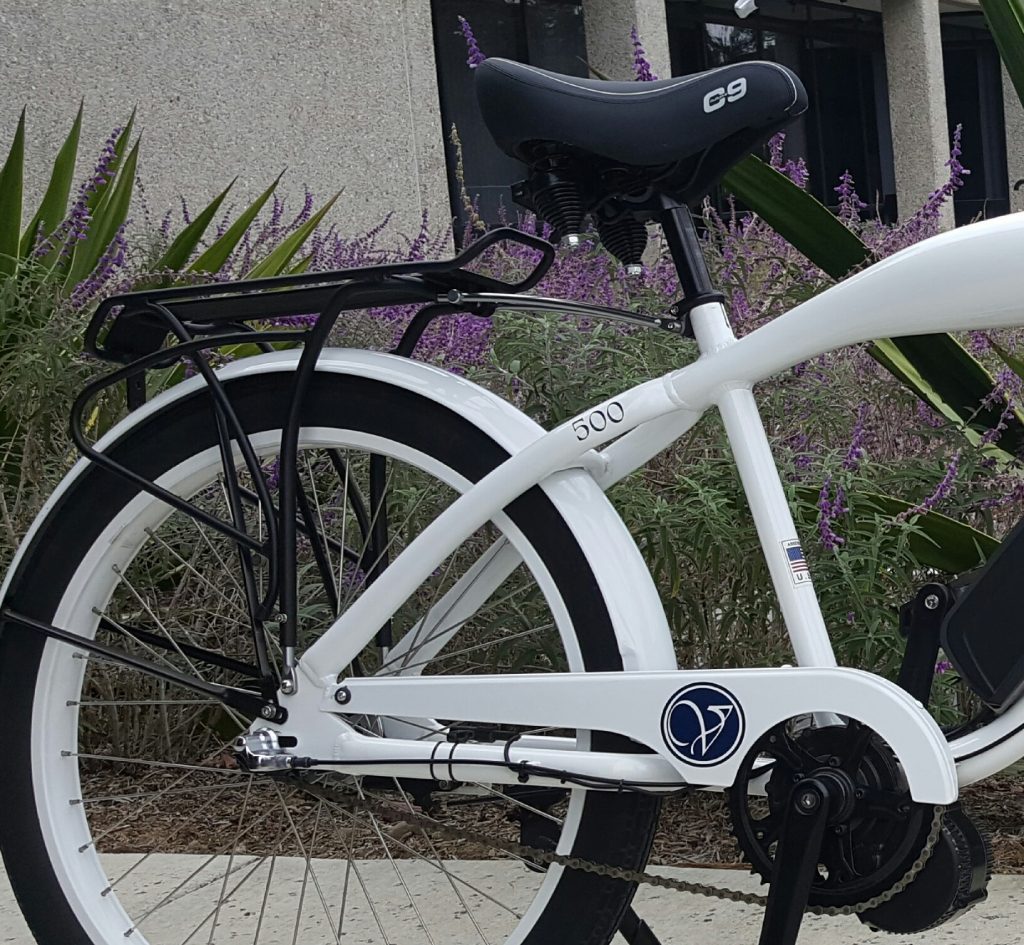 A white electric bike parked in front of a building.